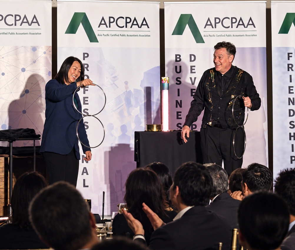 Brock Edwards performing the linking rings with a volunteer during a comedy magic show at a corporate event