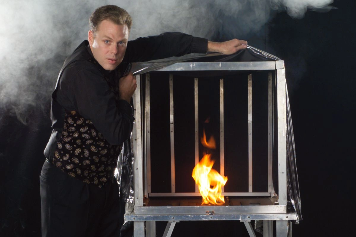 Corporate illusionist Brock Edwards performing the Fire Cage grand illusion during his illusion show