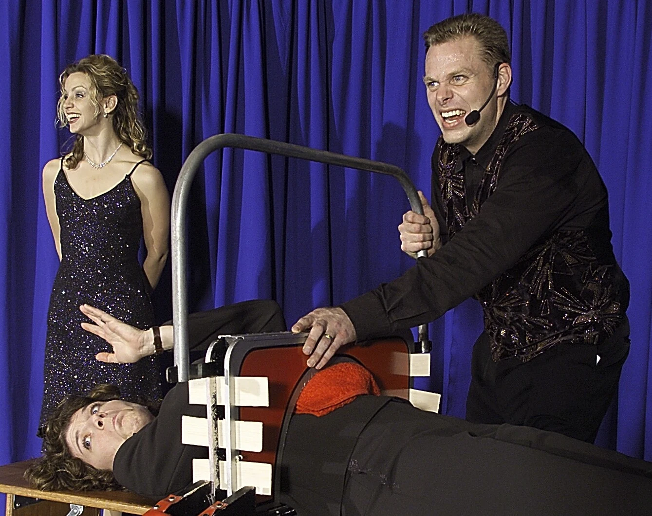 Corporate illusionist Brock Edwards sawing a volunteer in half on stage