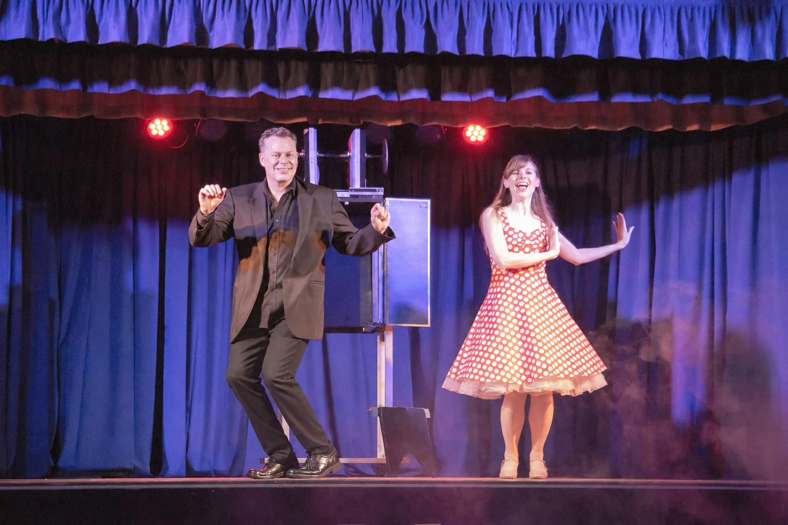 Brock Edwards dancing on stage with his professional dancer assistant during a holiday party magic show